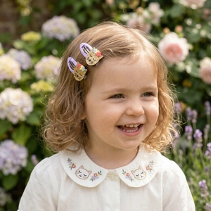 Close-up of cute purple polka dot cat hair clips with glitter ears for little girls