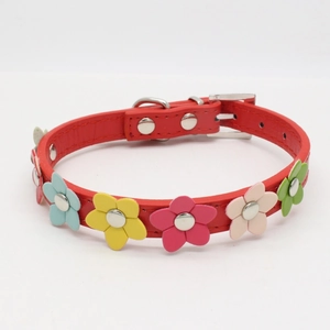 Detail of red leather pet collar with colorful floral charms and silver metal hardware