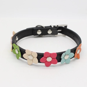 Detail of black leather dog collar featuring colorful leather flowers and metal hardware