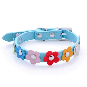 Macro detail of sky blue faux leather dog collar with colorful floral appliques and metal buckle