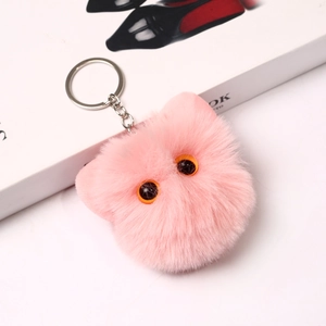 Cute pink furry cat head keychain with orange eyes and silver metal clasp hanging
