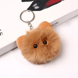 Close-up of 8cm plush cat head keychain with soft brown fur and large orange eyes