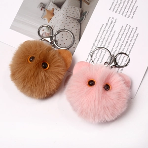 Close-up of pink and brown plush cat keychains with soft faux fur and metal clips