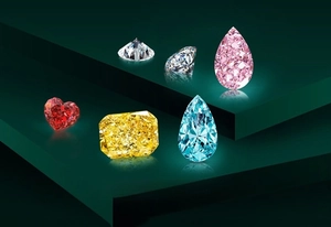 Detailed display of mixed cut gemstones including heart and pear shapes in vibrant colors