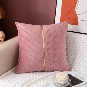 Detail of rose pink velvet decorative pillow with gold metal strip and pleated texture