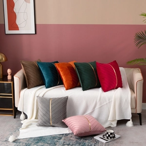 Detail of luxury velvet throw pillows featuring pleated texture and gold metal accent decor