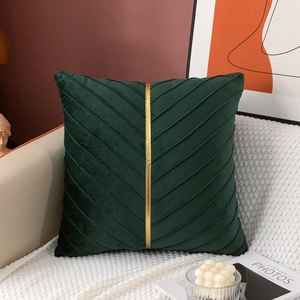 Detail of dark green velvet pillow with diagonal pleats and a gold vertical stripe