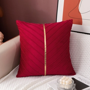 Detail of burgundy velvet pillowcase with diagonal pleats and golden vertical ribbon
