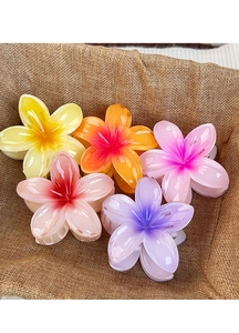 Set of five colorful gradient plumeria flower hair claws on natural burlap fabric