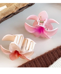 Detail of pink and peach floral hair claws with gradient texture on knit fabric