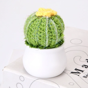 Close-up of handmade crochet cactus with yellow flower in a white ceramic pot