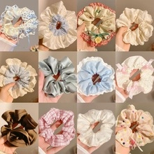 Detail van 12 diverse scrunchies in satijn en katoen met stippen en ruitpatronen