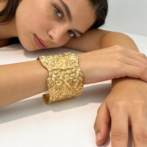 Modern gold cuff bracelet with geometric pleated texture in a minimalist bold design