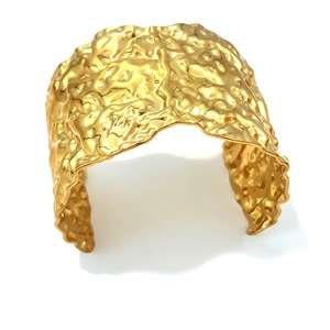 Wide gold geometric cuff bracelet with irregular wrinkled metal texture on white background