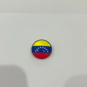 Vista detallada de un pin circular de la bandera de Venezuela con acabado brillante esmaltado