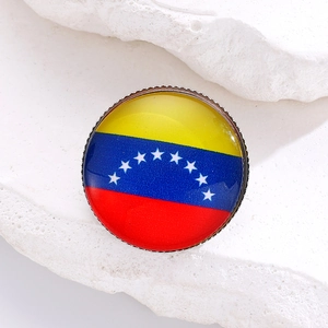 Detail of a round Venezuela flag brooch with colorful stars and serrated metal edge