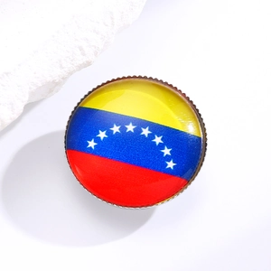 Detail of round Venezuela flag brooch with colorful crystals and polished resin finish