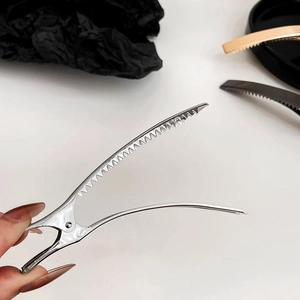 Close-up of a large silver metal duckbill hair clip with serrated teeth design