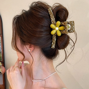 Detailed side view of a large olive floral hair claw clip with yellow flower decoration