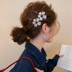 Detailed view of iridescent resin flower hair clips styled on a stylish brown hair bun