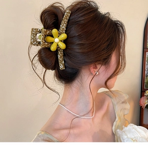 Close-up detail of a forest style flower hair claw clip worn on elegantly styled brown hair