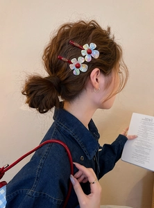 Detail view of iridescent resin flower hair clips elegantly styled on model's hair.