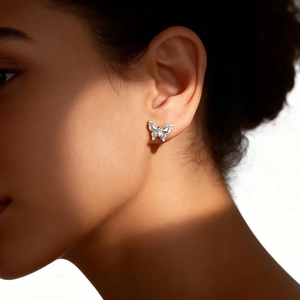 Détail d'une boucle d'oreille papillon en argent avec zircons sur un mannequin