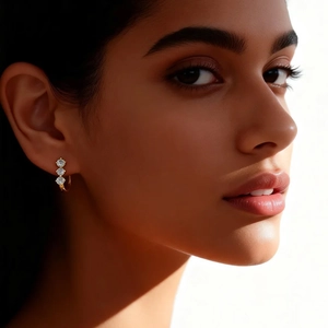 Close-up of golden U-shaped hoop earrings with three inlaid sparkling round zircons