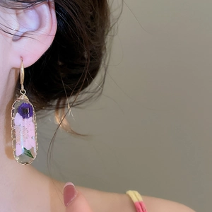 Dettaglio orecchini in resina pastorale con veri fiori secchi rosa e viola con gancio dorato