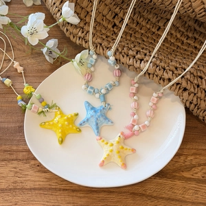 Detailed view of colorful starfish beaded necklaces on a white plate for beach vacation