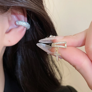 Detailed view of a luxurious gold zircon-encrusted ear cuff with a cross pendant design