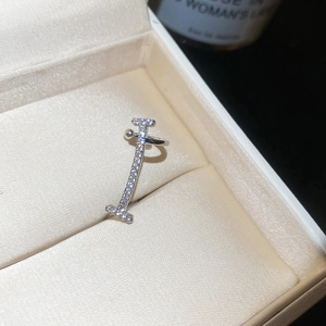 Macro detail view of a silver zircon-encrusted ear cuff presented in a beige jewelry box