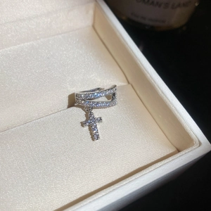 Detail view of a sparkling zircon cross ear cuff in a premium jewelry gift box.