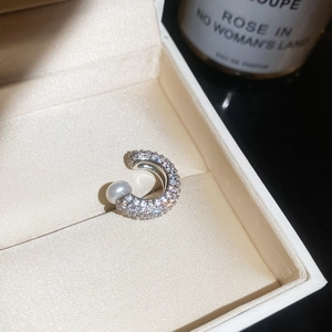 Detailed macro view of a silver-tone zircon pavé ear cuff with a single pearl in a gift box