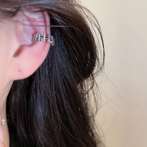 Close-up view of a silver-toned ear cuff with 'MIU' lettering and sparkling zircon crystals