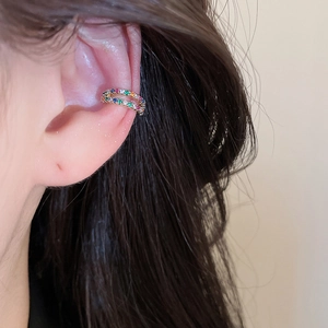Macro detail of a sparkling rainbow zircon double-row ear cuff on a female ear