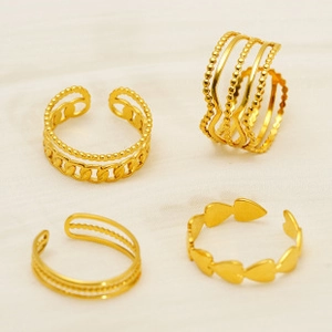 Detailed view of four 18K gold plated stainless steel rings including heart and chain styles
