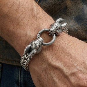 Close-up of vintage silver men's bracelet with dual rabbit heads and braided steel chain