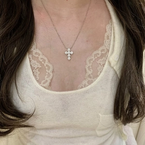 Close-up of a sparkling cubic zirconia cross pendant necklace worn on the neck