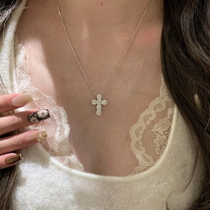 Elegant silver zircon cross pendant necklace for women shown on a model's neckline