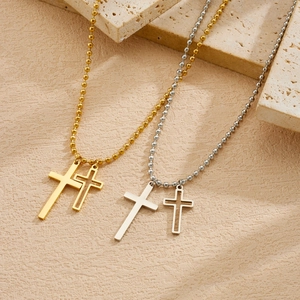 Detailed view of gold and silver stainless steel double cross pendant necklaces.
