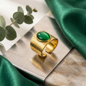 Primo piano di anello vintage dorato con pietra occhio di gatto verde e motivo a raggi