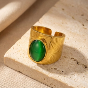 Dettaglio anello vintage a fascia larga con motivo a raggiera e pietra occhio di gatto