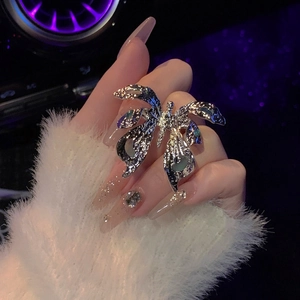 Close-up detail of textured silver butterfly ring with blue enamel worn on hand.
