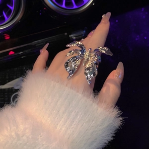Detail view of silver oversized butterfly ring with crinkled texture on finger