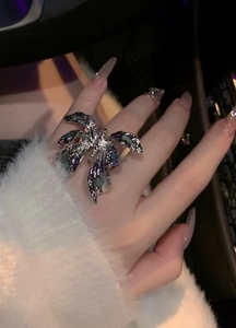 Close-up of an aesthetic silver butterfly ring with dark iridescent oil-dripped enamel