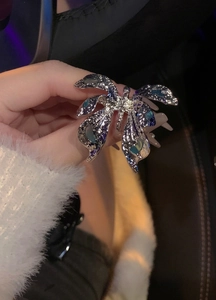 Detailed view of large silver butterfly open ring with textured wings and blue enamel