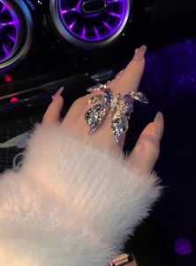 Silver butterfly wrinkled open ring worn on finger with purple car interior background