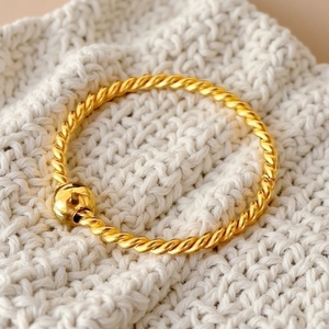 Dettaglio dell'anello in acciaio al titanio placcato oro 18K con design a fune