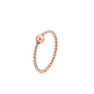 Dettaglio macro di un anello a corda in oro rosa con una singola sfera metallica lucida.